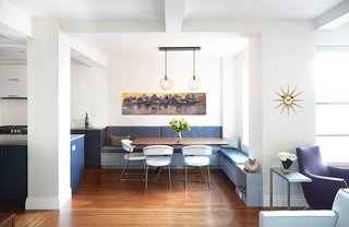 A modern breakfast nook boasts an abundance of natural light and a large, multi-functional space with built-in storage.