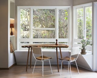 A beautifully simple shiplap built-in banquette balances perfectly with a live edge table, making the most of the abundant natural light. 