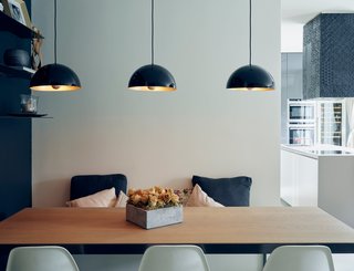 Three simple light fixtures with a pretty brass finish add a warm glow to a cool-toned room. 