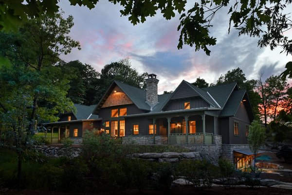 Grove Lodge at Mohonk Mountain House - The 7,000-square-foot two-story Grove Lodge incorporates the use of native stone and natural finishes to help it blend into the scenic landscape of the Mohonk Mountain House property.
Interior spaces include hardwood floors and the use of exposed wood throughout. The guest rooms have their own separate drive-up entrances and feature either a stone patio (lower level) or balcony area. All areas are appointed with our rustic rocking chairs for outdoor seating.
Eco-friendly features include sustainable building materials, LED lighting, and a geo- thermal heating and cooling system. 250-tons of Shawangunk conglomerate excavated from the site have been recycled into the retaining walls and the stone fireplace. Photo 5 of Grove Lodge at Mohonk Mountain House modern home