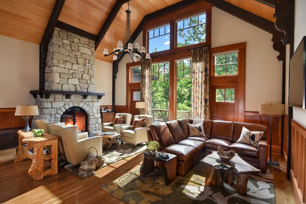 The 7,000-square-foot two-story Grove Lodge incorporates the use of native stone and natural finishes to help it blend into the scenic landscape of the Mohonk Mountain House property.
Interior spaces include hardwood floors and the use of exposed wood throughout. The guest rooms have their own separate drive-up entrances and feature either a stone patio (lower level) or balcony area. All areas are appointed with our rustic rocking chairs for outdoor seating.
Eco-friendly features include sustainable building materials, LED lighting, and a geo- thermal heating and cooling system. 250-tons of Shawangunk conglomerate excavated from the site have been recycled into the retaining walls and the stone fireplace. Photo of Grove Lodge at Mohonk Mountain House modern home