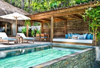 Escape to the Jungle in One of These Modern Forested Retreats - Photo 10 of 10 - Nihiwatu is a cluster of luxury bale villas on Sumba, one of the more remote islands of Indonesia. Interiors are furnished with tropical hued fabrics, warm woods, rattan, soft drapery, and local artifacts. 