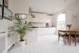 Soak Up the Creative Vibes of London’s East End at One of These Rental Homes or Hotels - Photo 5 of 9 - With white walls and wooden floors, subway tile backsplashes in the kitchen, potted plants, and jungle-inspired wallpaper, this simple one-bedroom apartment is just a short walk from Hackney Central Overground Station and feels much larger than its actual size.