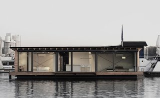 Make Yourself at Home in One of These Small Spaces on Boats That You Can Rent - Photo 6 of 10 - Moored in Lake Rummelsburg in Berlin, this 60-square-meter houseboat has full-height windows that open to views of the water and the city horizon. It has a large living area, open kitchen, and a fireplace—and can comfortably accommodate two adults and two children. 