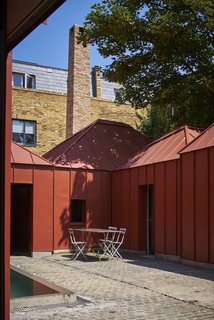 10 Homes With Large, Well-Ventilated Courtyards - Photo 8 of 9 - Six earth-colored, metal-clad pavilions were combined to create Tin House, an innovative and voluminous house that boasts a secluded rectangular pool in a bright interior courtyard.