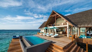 9 Modern Maldivian Resorts With Spectacular Overwater Villas - Photo 7 of 9 - Sited within 44 acres of the Unesco World Biosphere Reserve in the Baa Atoll, the thatched water villas at this resort are designed with floor-to-ceiling windows for panoramic ocean views.
