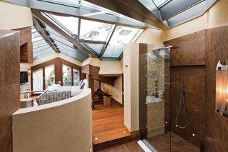 7 Alpine Holiday Chalets in Switzerland - Photo 7 of 7 - Built into the side of the mountain, Zermatt Peak is an expansive holiday retreat that has an indoor and outdoor jacuzzi, gym, sauna, steam room, and walk-in wine cellar.
