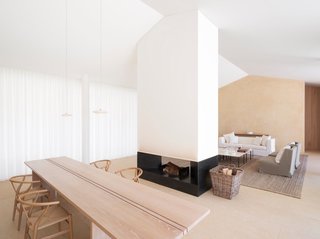 Designed by London architect John Pawson, this home in Saint Tropez has a freestanding fireplace framed by clean lines and bright white walls that acts as the heart a dynamic open-plan living room.