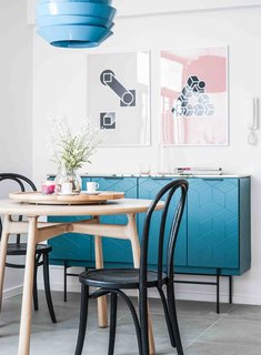 10 Small Apartments by a Hong Kong Design Studio That Are Less Than 1,000 Square Feet - Photo 2 of 10 - Tiles with colored grouting and a metallic blue cabinet with geometric graphics are some of the unique features of this home. A bedroom is hidden behind a television cabinet that merges with the open kitchen.