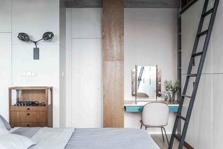 10 Small Apartments by a Hong Kong Design Studio That Are Less Than 1,000 Square Feet - Photo 4 of 10 - 1930s modernism reigns in this studio flat, where a cabinet is used to separate the open-plan living, sleeping, and storage zones. Carefully selected loose furnishings, such as a denim-upholstered sofa by Stephen Kenn and a midcentury chest by Charlotte Perriand, expand the scale of the interior, making it feel roomier than its actual size.