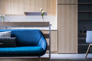 10 Small Apartments by a Hong Kong Design Studio That Are Less Than 1,000 Square Feet - Photo 7 of 10 - To open up the space visually, JAAK incorporated storage into a single wall that’s positioned next to an open kitchen. This frees up the other three walls and makes the apartment look much bigger. 