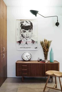 10 Small Apartments by a Hong Kong Design Studio That Are Less Than 1,000 Square Feet - Photo 8 of 10 - Mixing midcentury modern with pops of color, Eliza’s apartment has a full-height storage system that's built into one of the living room walls.