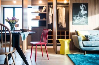 10 Small Apartments by a Hong Kong Design Studio That Are Less Than 1,000 Square Feet - Photo 9 of 10 - Three pivot-hinged doors divide the dining room from the study area. When the door is opened, the dining room expands to include the study. 