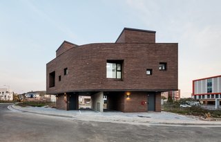 10 Modern Structures That Use Brick in Interesting Ways - Photo 7 of 10 - This home in Korea has a brick facade and interior walls that omit vertical construction joints. Instead, it's comprised of bricks that are stacked with an outward twist, which gives the facade a look that recalls the scales of a snake or a tree's bark. 