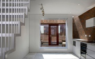 10 Modern Structures That Use Brick in Interesting Ways - Photo 8 of 10 - Inspired by the traditional red brick houses in Dublin, this home features exposed brick walls that begin in the interior kitchen, extend out to a skylit sitting area, and finally continue onto an outdoor courtyard. 