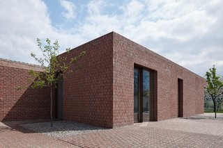 10 Modern Structures That Use Brick in Interesting Ways - Photo 9 of 10 - Constructed almost entirely of red brick, this clean-lined, L-shaped row house in the Czech Republic juxtaposes walls of vertically laid bricks with walls of horizontally laid bricks. The pavements along the gardens surrounding the house are laid with the same type of bricks. The overall effect is a home that looks as if it grew from a ground of bricks.