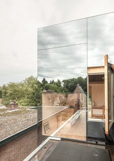 8 Structures and Spaces That Use Mirrored or Reflective Surfaces in Interesting Ways - Photo 8 of 8 - With an extension clad in mirrored glass that reflects the silhouettes of the existing brick house, "Mirror Mirror" is a home that shields its residents from view during the day, but exposes the extension's interiors at night.