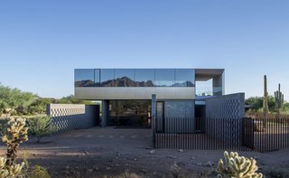 8 Structures and Spaces That Use Mirrored or Reflective Surfaces in Interesting Ways - Photo 1 of 8 - Szu-Ping Patricia Chen Suchart and Thamarit Suchart of Chen + Suchart Studio used brushed-stainless steel and glass on the upper volume of this Sonoran Desert home. The glass, which was treated with a thermal coating, provides protection from the sun and creates a surface with a silvery, mirrored effect that captures the colors of the desert and mountain peaks.
