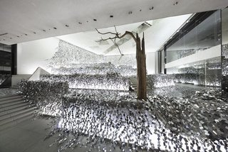 8 Structures and Spaces That Use Mirrored or Reflective Surfaces in Interesting Ways - Photo 2 of 8 - Japanese designer Nendo cut mirrored, stainless-steel sheets into 2,000 rhombus-shaped sections, which he then strung together into an "ivy of mirrors." The installation of reflective shards is spread across a layered stone garden within the Sogetsu School of Ikebana in Tokyo.