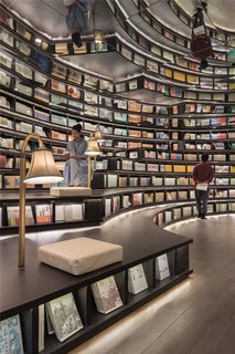 8 Structures and Spaces That Use Mirrored or Reflective Surfaces in Interesting Ways - Photo 3 of 8 - In Hangzhou, China, Shanghai-based XL-Muse designed the Zhongshuge bookstore with forest-like rows of vertical, circular bookshelves and ceilings covered with mirrors. The mirrors make the shelves look much taller than they really are and give the reading hall a dream-like, Dali-esque quality.