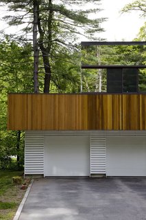 8 Structures and Spaces That Use Mirrored or Reflective Surfaces in Interesting Ways - Photo 5 of 8 - Using mirrored siding and plate-glass windows, Boston architect Stephen Chung created an optical illusion where the second-story of a house surrounded by nature disappears seamlessly between the foliage and gabled roofs nearby.