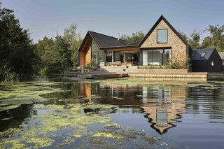 9 Traditional-Turned-Modern Cottages You Can Rent in the UK - Photo 1 of 9 - This RIBA award-winning house by Platform 5 Architects has three pitched-roof bays that are clad in shingles. The design is inspired by Scandinavian lake houses and echoes the form of local boat sheds.