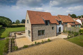 9 Traditional-Turned-Modern Cottages You Can Rent in the UK - Photo 9 of 9 - When remodeling this 300-year-old cottage, architect Miljana Salinovic installed steel frames in order to preserve the texture of the traditional flint walls. A new extension was also added, which is clad in charred cedar. 