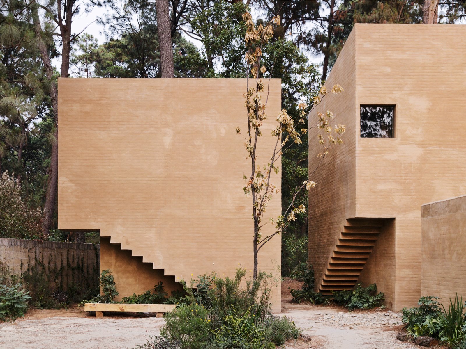 The interior staircases are cut out from the façade to reveal a saw-toothed, hollowed out space on the lower corners of the exterior walls.