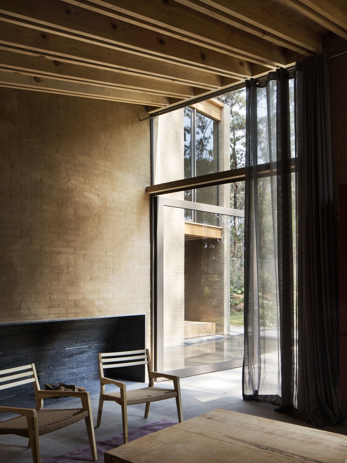 A full height glass doors connects the living areas with the courtyard and forest outdoors.