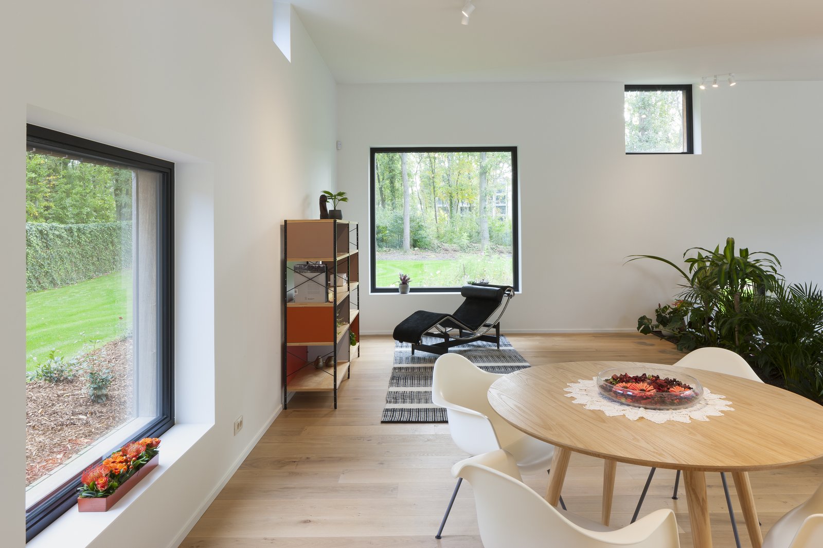 A black Arne Jacobsen Series 07 chair from Fritz Hansen, Eames storage shelf from Vitra and white Eames DAX plastic armchairs.