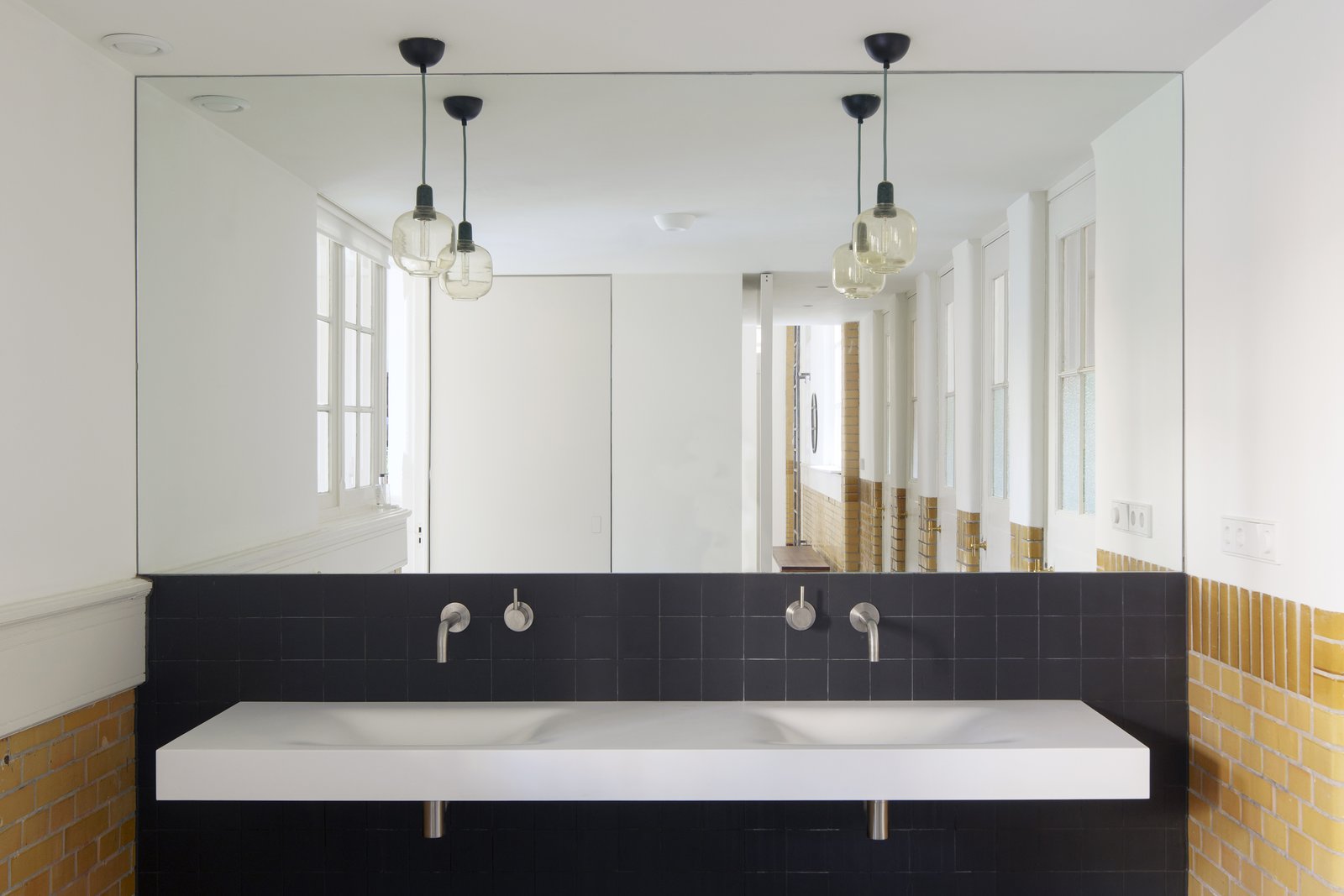A mirror placed across the rear wall of the bathroom allows users to experience the original length of the school hallway.