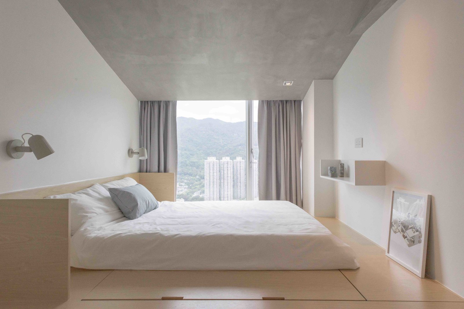 Fuss-free aesthetics continue into the master bedroom, where a sloped roof with concrete paint hides the ceiling beam.
