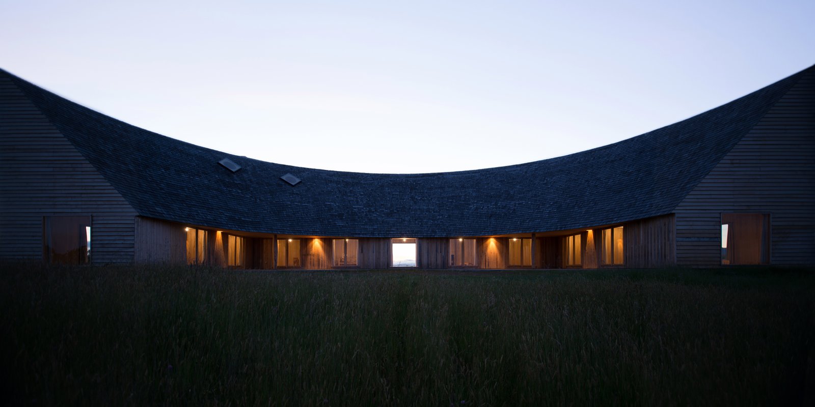 A sweeping, arc roof that slopes steeply on one side.