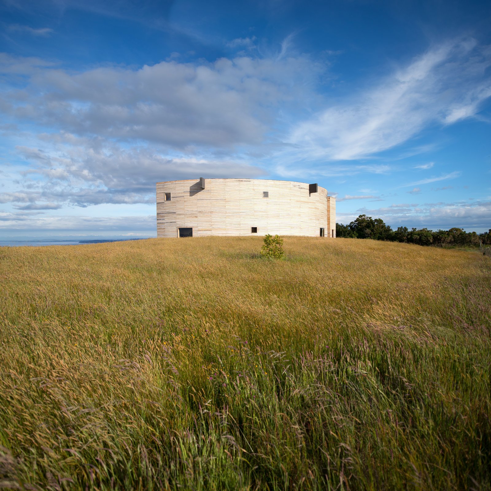 The house is set within an expansive meadow.