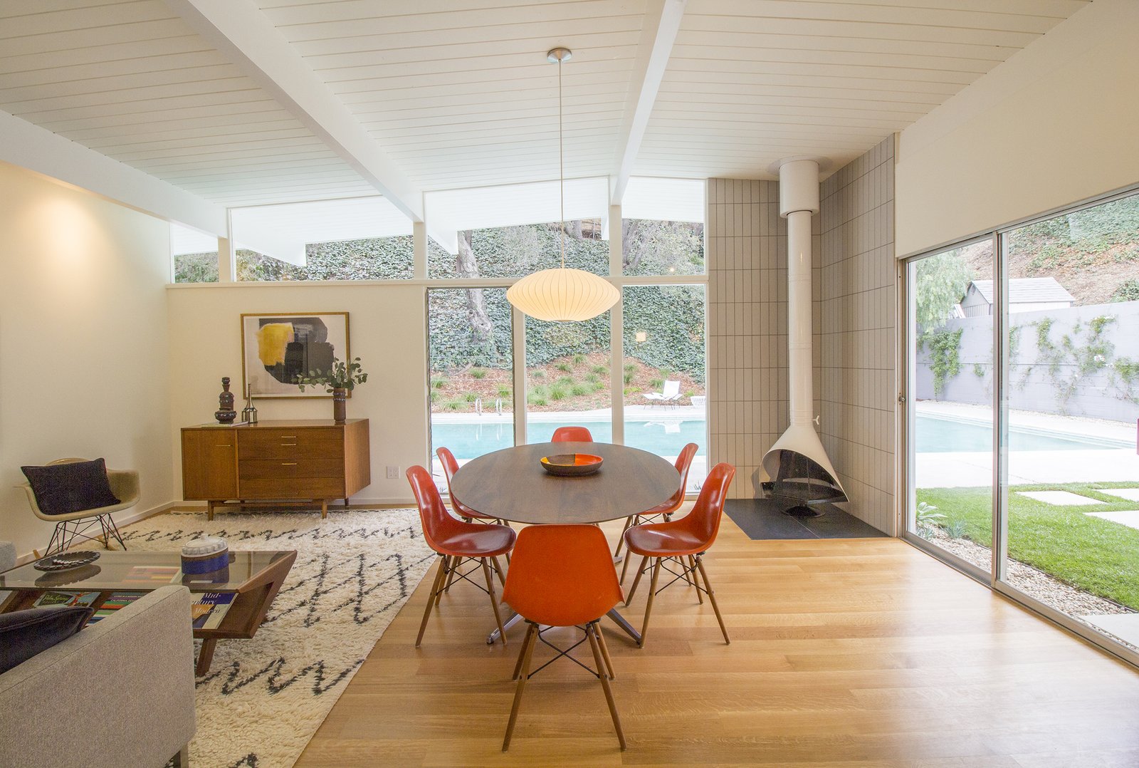 The open-plan living and dining area connects to an outdoor patio and the pool.