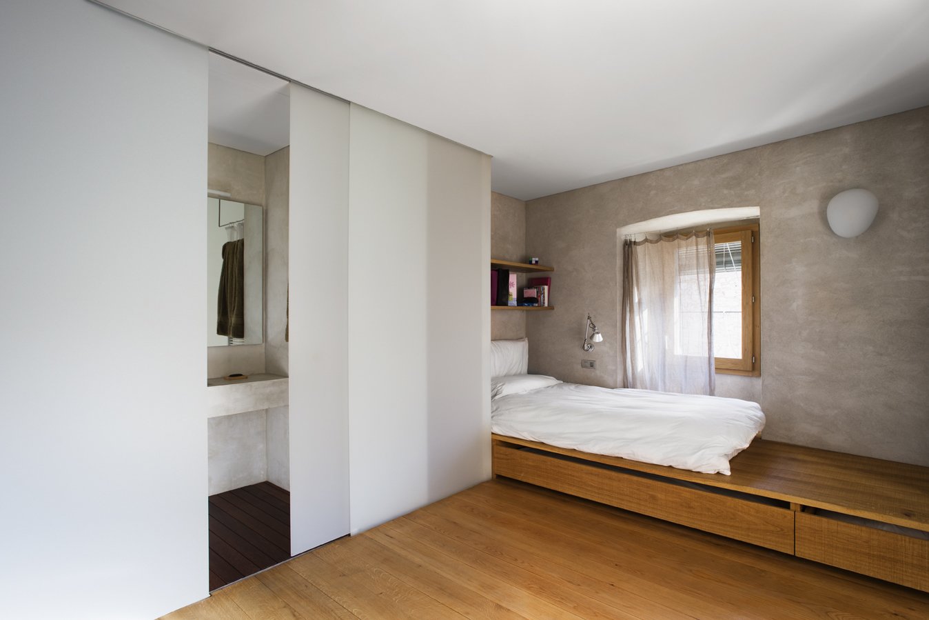 A warm and simple bedroom with an ensuite bathroom.