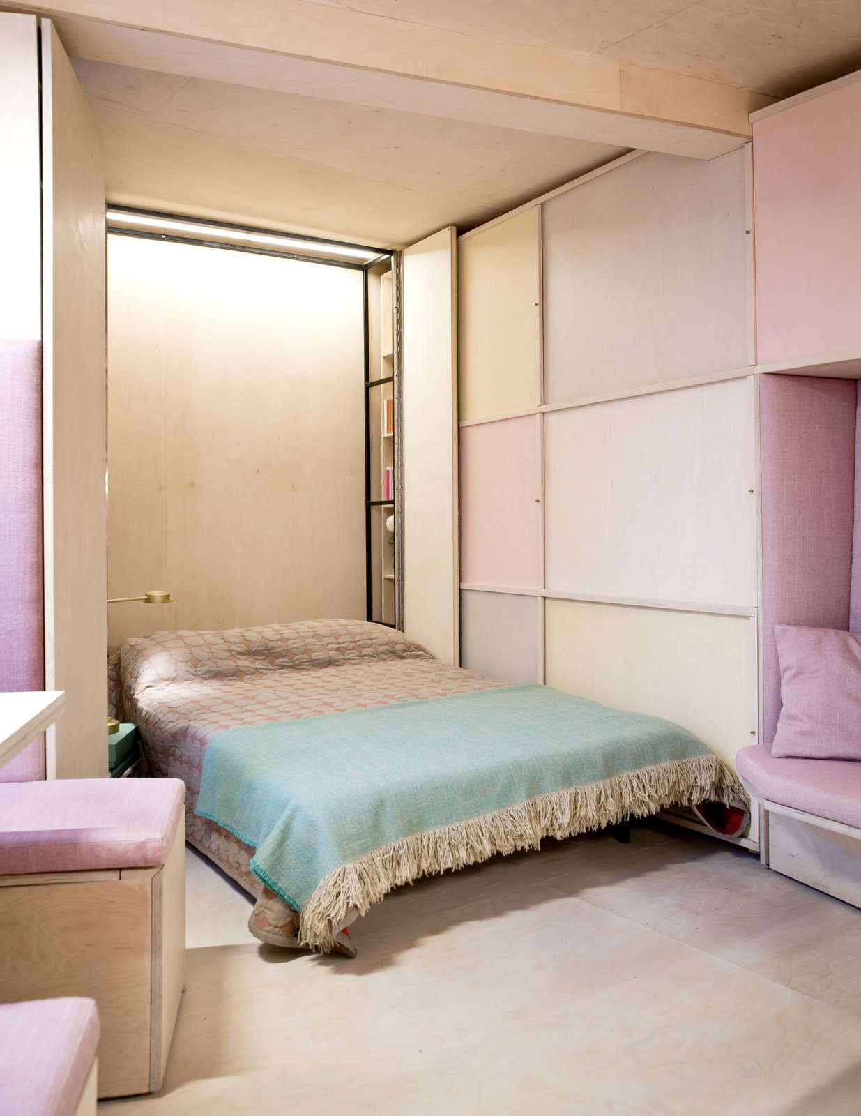 A Murphy bed located along the narrowest wall of the triangular-shaped apartment.