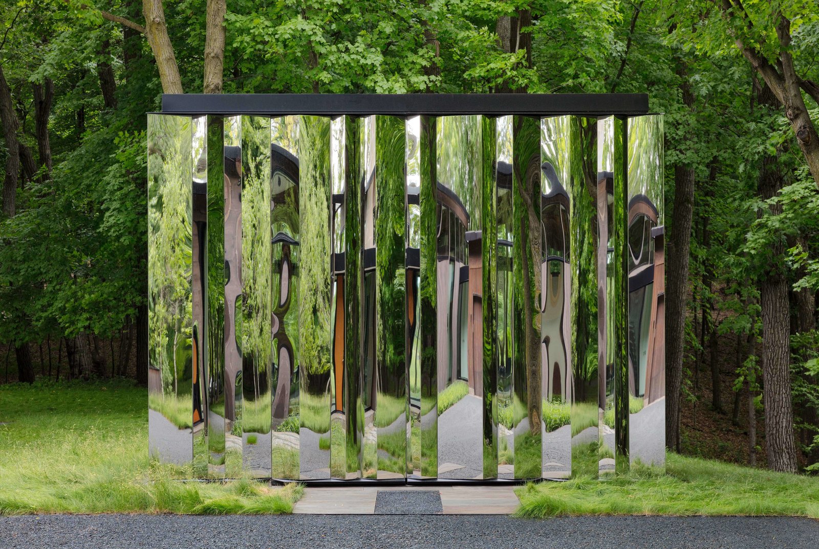The mirrored surface of the shed reflects delightfully distorted images of the natural surroundings.