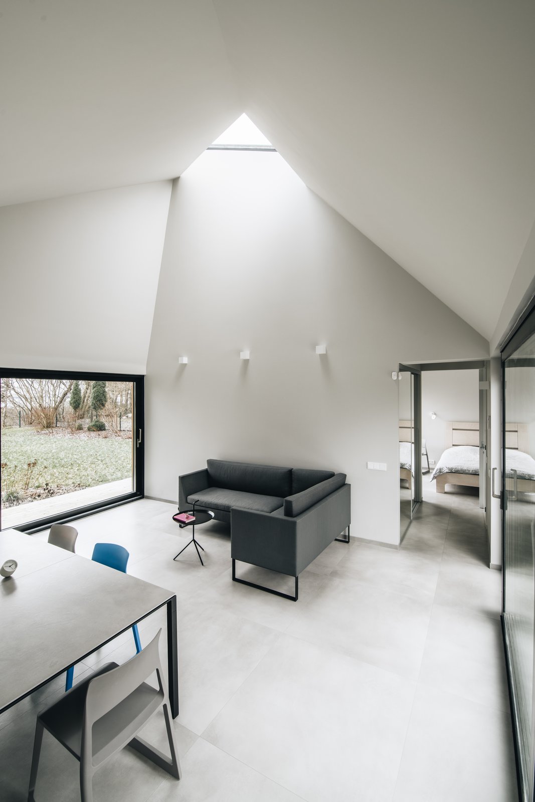 Fully-glazed walls on two sides, and a triangular skylight flood the living areas with light.