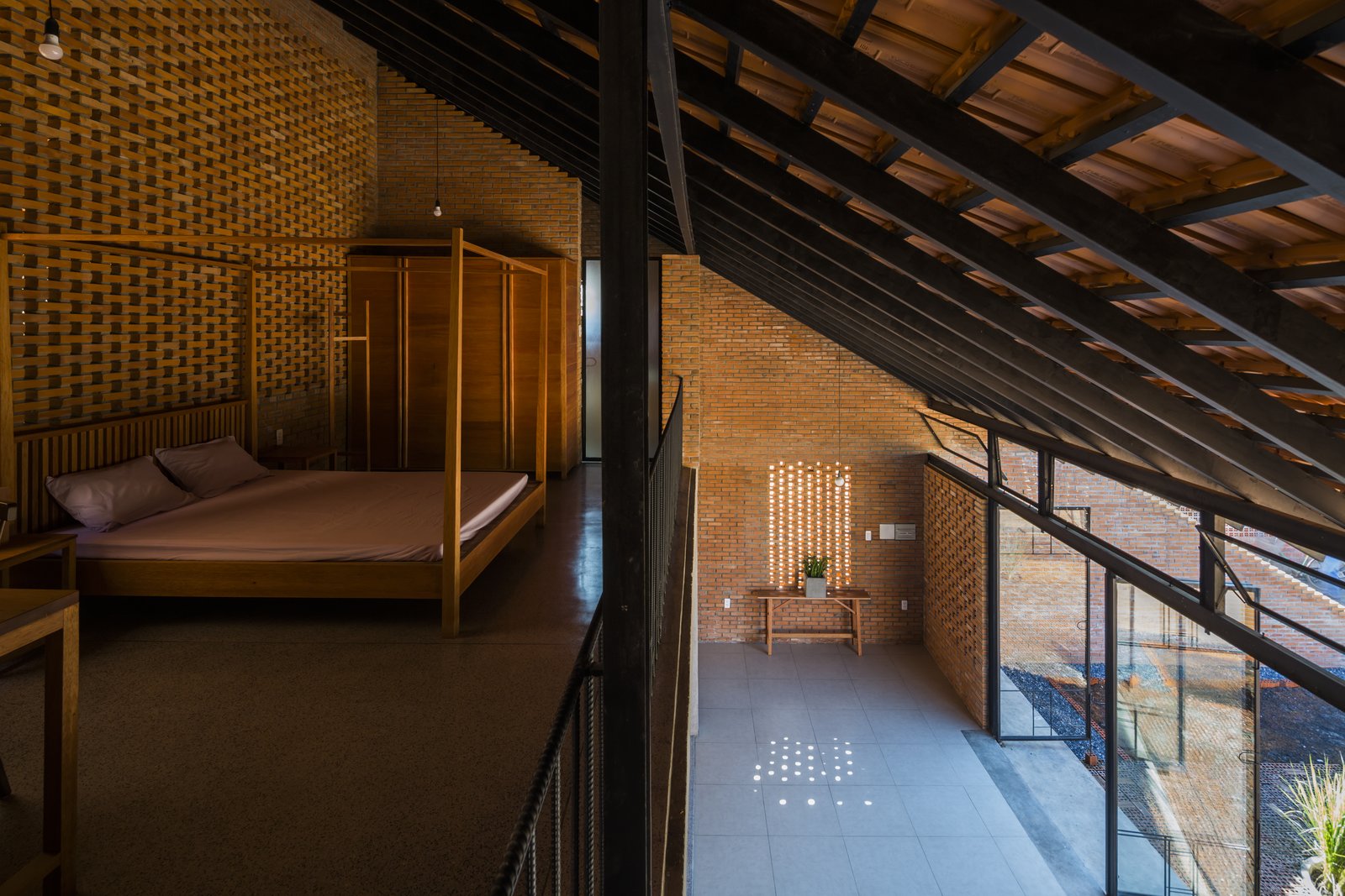 The mezzanine bedroom looks down to a buffer space between the front yard and the living areas.