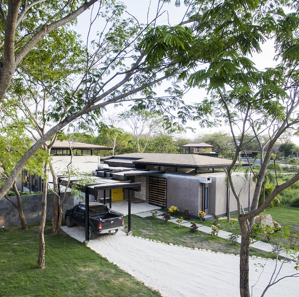 A shaded parking lot near the entrance of the house.