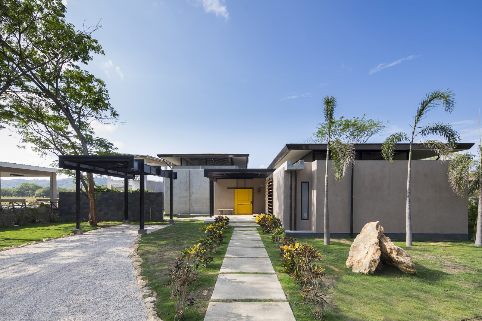 A bright, yellow door serves as the main entrance to the house.