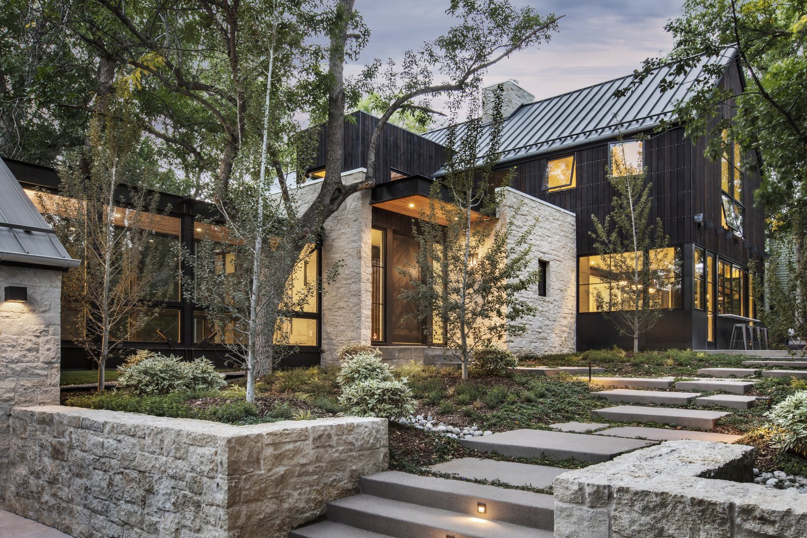 The home is composed of limestone masonry and structural steel accents.