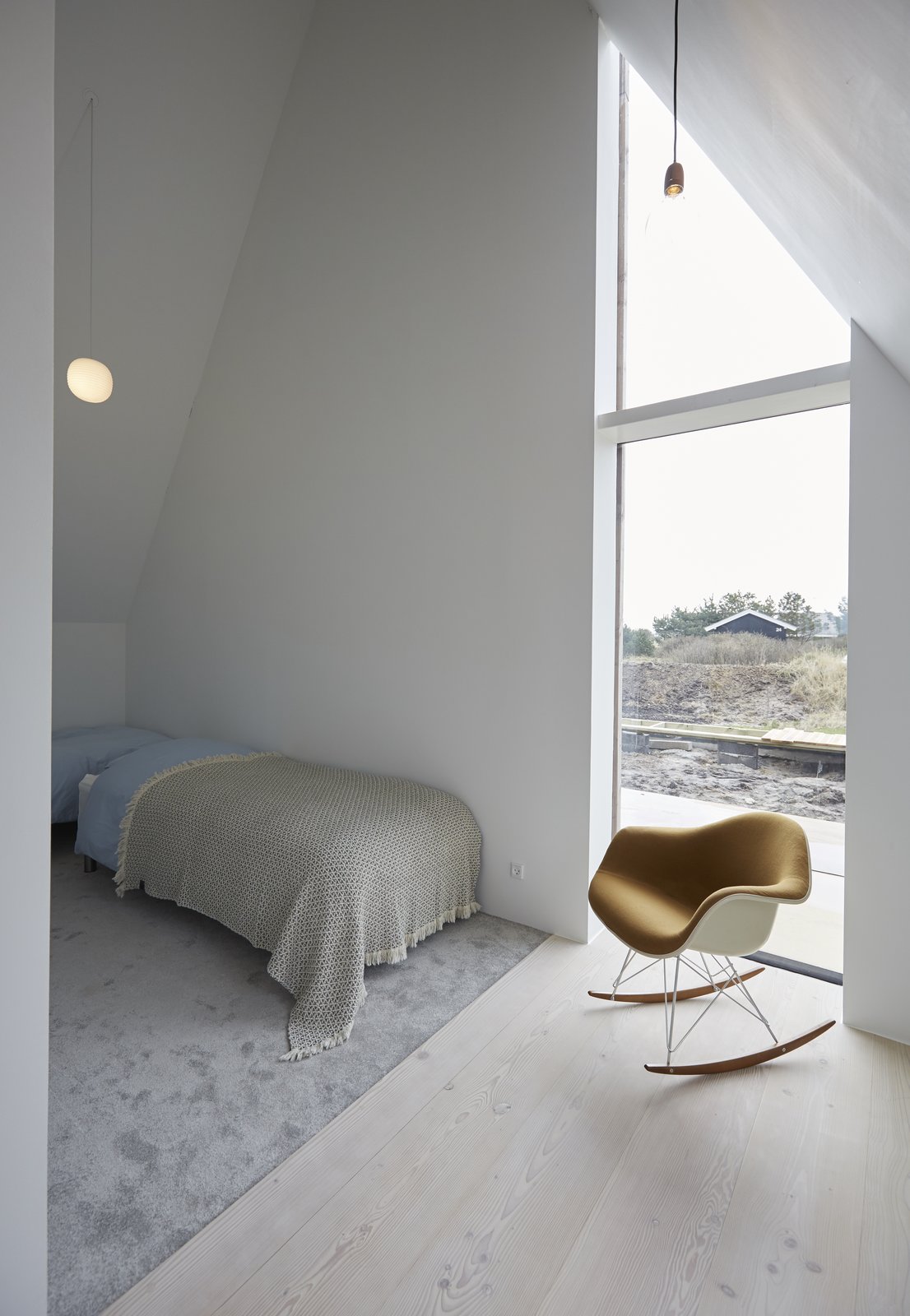 A full-height window frames views of the dunes.