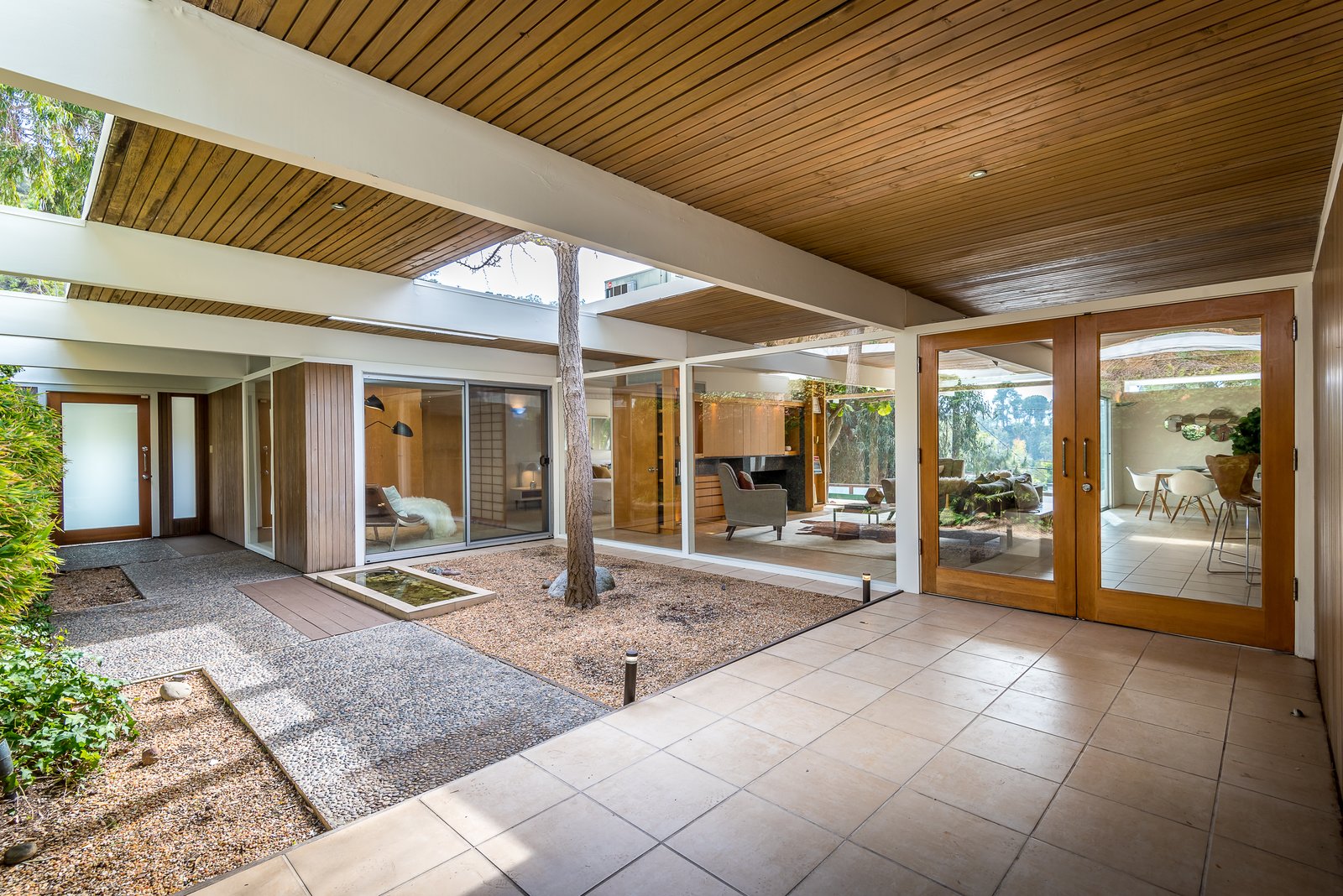 The sliding glass doors connect the interiors to the outdoor terraces and pool.