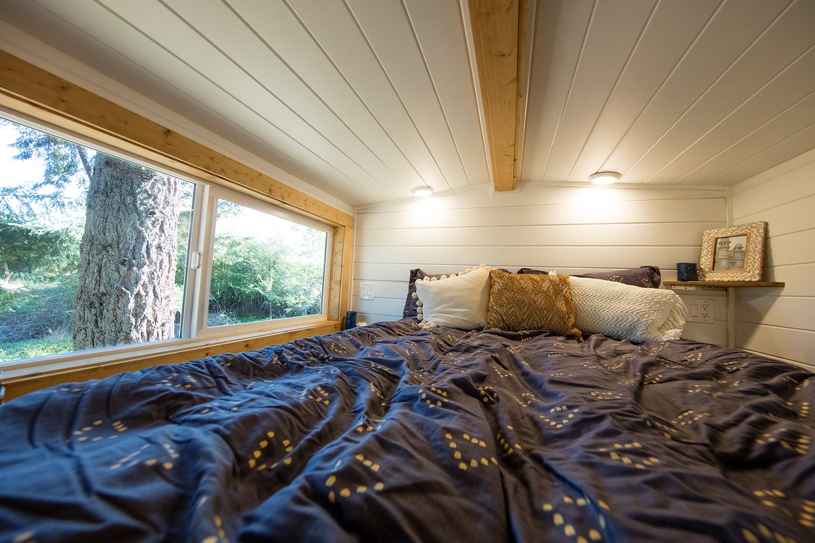 A lofted sleeping nook above the bathroom.