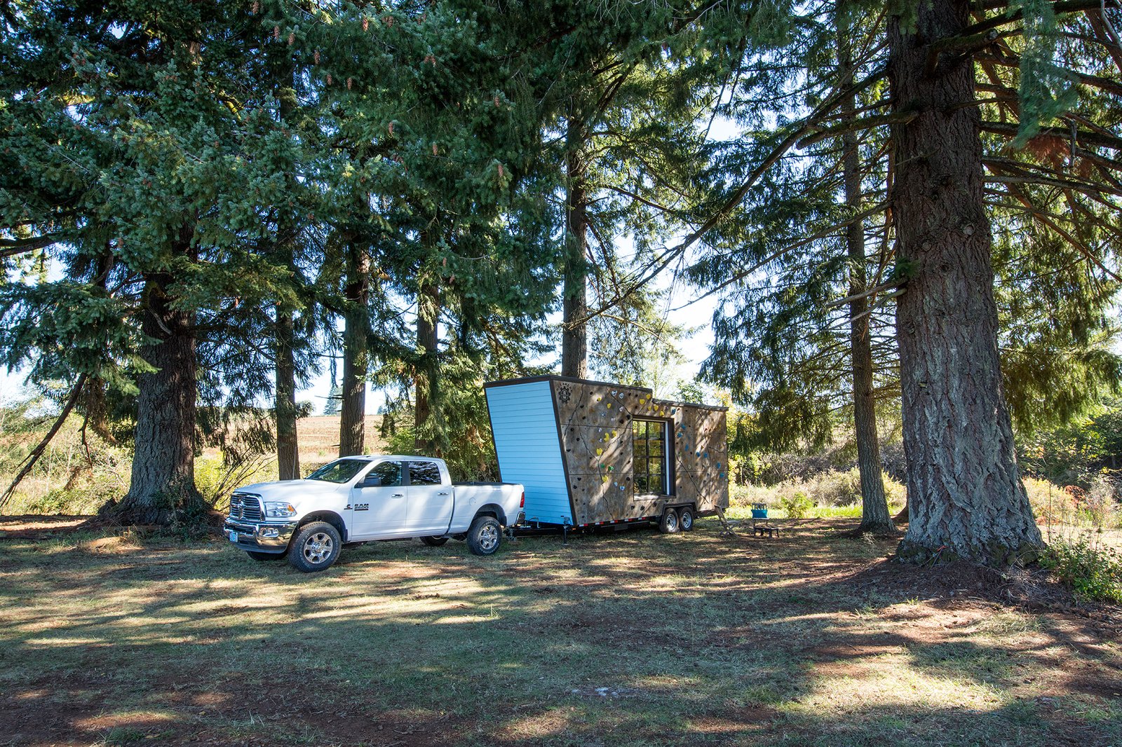 This 28-foot long, towable, double-axle trailer home, has a front façade that’s a rock climbing wall.