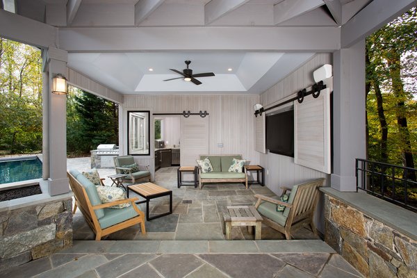 Sun bathers can escape the heat while dining on the flagstone patio under the ceiling fan or warm up while the gas fire pit is operating. see the full case study, http://www.markivbuilders.com/outdoor-kitchen-bethesda-maryland/ Photo 9 of Outdoor Kitchen and Patio modern home