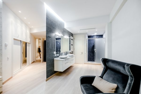 The house is spacious and the interior was designed in a manner, which kept this aspect highlighted: the entrance corridor leads to the large open area, uniting the kitchen, the living room and the dining room; The guest room wall, concealing the wardrobe, has two large incisions, making the wardrobe still part of the bedroom. Compelling design choice was also made for the master bedroom, where two sinks are not shying away from eye, but are rather put on display, as integral element of the bedroom.
Photo 9 of InnerEdges modern home