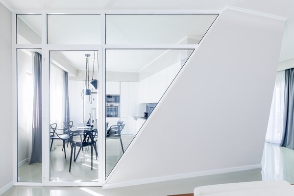 As soon as you enter the space, the core aesthetic of the design unfolds and it is only possible to see the main room through the tilted hallway. It meant to take your time for the idea of an actual comfort, smartness and practicality of the design to sink in. When navigating further into the room, one realizes, that the slopes direct the visitor from the narrow spaces toward the wider ones and vice versa. Leaning walls bend the space, making it simultaneously modest and sharp.
The intention of diagonal walls being directional carries through the bedroom as well, but here, the steepness accentuates the workstation. In the case of the bathroom, the slope serves as a surface to lean on and relax. Photo 12 of Cave modern home